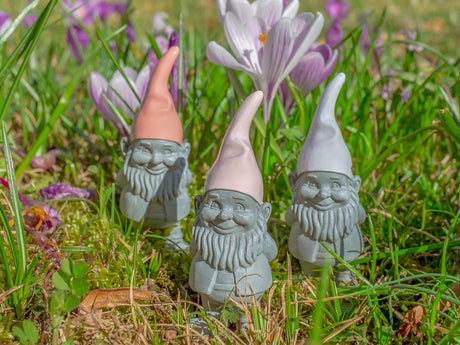 A ceramic garden gnome peeking out from a planted border in a well-designed Surrey garden