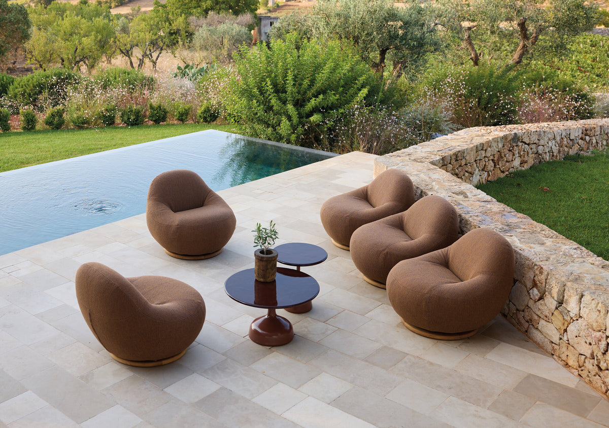 Cane-line Gem swivel lounge chairs around Glaze coffee tables beside a pool